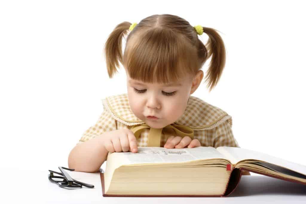 Cute cheerful child with book, isolated over white